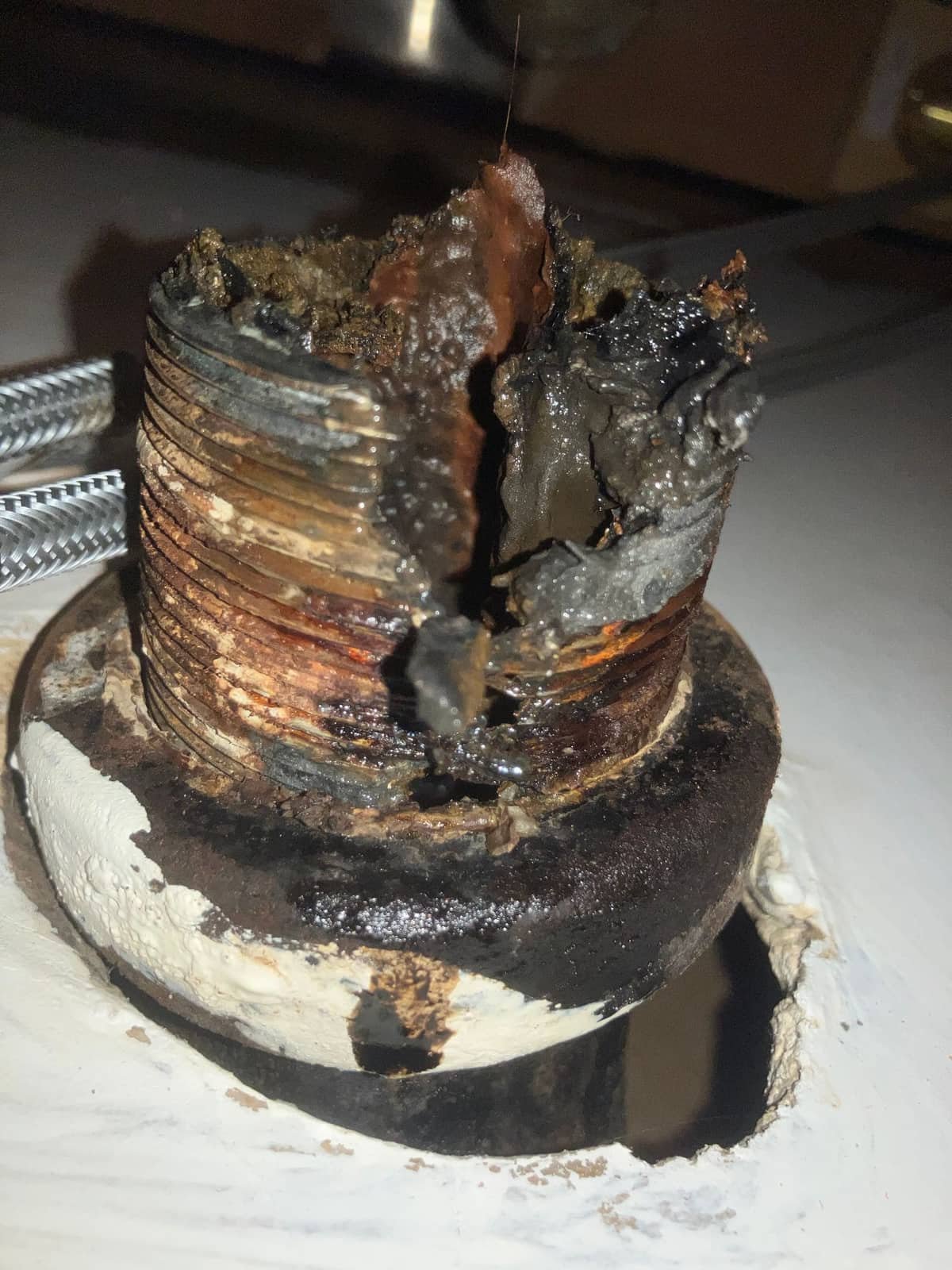 Corroded galvanized pipe fitting found during a plumbing inspection, showing heavy rust buildup